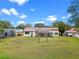 Wide shot of the property's spacious backyard and well-manicured lawn, complemented by mature trees at 6766 Edgeworth Dr, Orlando, FL 32819