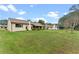 Spacious backyard showcasing the property's ample green space and the rear exterior of the home at 6766 Edgeworth Dr, Orlando, FL 32819