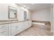 Bright bathroom featuring double vanity, marble countertop, and tiled soaking tub at 6766 Edgeworth Dr, Orlando, FL 32819