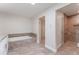 Bathroom featuring marble flooring, a soaking tub, and a glass-enclosed shower with grab bars at 6766 Edgeworth Dr, Orlando, FL 32819