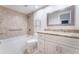Bathroom featuring marble countertop, bathtub with showerhead, and tiled walls at 6766 Edgeworth Dr, Orlando, FL 32819