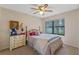 Cozy bedroom with natural light from the window and light colored walls and furnishings at 6766 Edgeworth Dr, Orlando, FL 32819