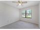 A tidy bedroom featuring a ceiling fan and a window with a lawn view at 6766 Edgeworth Dr, Orlando, FL 32819