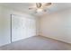 A simple carpeted bedroom featuring a ceiling fan and closet with bi-fold doors at 6766 Edgeworth Dr, Orlando, FL 32819