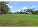 Scenic golf course view showcasing rolling green fairways and mature trees in a tranquil setting at 6766 Edgeworth Dr, Orlando, FL 32819