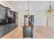Bright kitchen with dark cabinets, stainless steel appliances, a central island, and an adjacent living area at 6766 Edgeworth Dr, Orlando, FL 32819