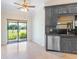 Kitchen area with a stainless steel dishwasher and sink under a window with access to the back yard at 6766 Edgeworth Dr, Orlando, FL 32819