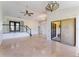 Large living area featuring tile floors, multiple ceiling fans, sliding glass doors, and staircase at 6766 Edgeworth Dr, Orlando, FL 32819