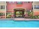 Community pool with clear blue water, surrounded by lush landscaping and comfortable lounge chairs at 911 N Orange Ave # 148, Orlando, FL 32801