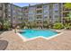 Inviting community pool surrounded by brick paving, lush landscaping, and comfortable lounge chairs at 911 N Orange Ave # 148, Orlando, FL 32801