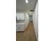 A hallway with wood flooring, white trim, white walls and white kitchen cabinets to the left at 1007 Colyer St, Orlando, FL 32805