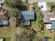 Aerial view of home with large backyard, a pool with screen enclosure and mature trees at 1157 Schooner Dr, Kissimmee, FL 34744