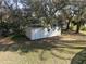 View of the outdoor storage shed showing the siding, door, and adjacent trees at 1157 Schooner Dr, Kissimmee, FL 34744