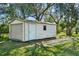 Storage shed features a roll up door, side entry door, and an adjacent window at 1157 Schooner Dr, Kissimmee, FL 34744