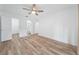 Bedroom featuring a ceiling fan, light wood laminate flooring with view to bathroom at 1188 La Mesa Ave, Winter Springs, FL 32708