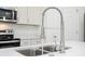 Close-up of the kitchen sink with a modern faucet and white countertops, complemented by stainless appliances at 13283 Sw 30Th Terrace Rd, Ocala, FL 34473