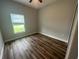 A vacant bedroom featuring a window with blinds and laminated wood flooring at 13745 Sw 43Rd Cir, Ocala, FL 34473