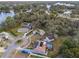 Aerial view showcasing a neighborhood with mature trees, multiple houses, and a community pool at 1456 Helena Ct, Deltona, FL 32725