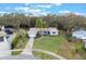 Aerial view of a charming home with a well-manicured lawn, long driveway, and mature trees at 1456 Helena Ct, Deltona, FL 32725