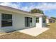 Backyard view featuring a concrete patio, windows, and a sliding glass door to the home's interior at 15204 Margaux Dr, Clermont, FL 34714