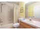 Bright bathroom with a shower and tub combo, yellow walls, and a single sink vanity at 15204 Margaux Dr, Clermont, FL 34714