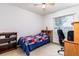 Neutral bedroom with a twin bed, a ceiling fan, and a work space by the window at 15204 Margaux Dr, Clermont, FL 34714