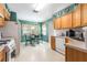 Cozy kitchen featuring wood cabinetry, white appliances and an adjacent dining area at 15204 Margaux Dr, Clermont, FL 34714