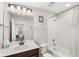 Bright bathroom with a shower/tub combo, white tile, and a dark wood vanity with a white countertop at 1547 Carey Palm Cir, Kissimmee, FL 34747