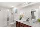 Bright bathroom with a glass door shower, wood cabinet and white countertops at 1547 Carey Palm Cir, Kissimmee, FL 34747