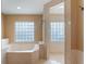 Bathroom with a large soaking tub, glass block window, and glass enclosed shower at 1585 Chestnut Ave, Winter Park, FL 32789