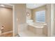 Bathroom features a large soaking tub with marble surround and glass block window at 1585 Chestnut Ave, Winter Park, FL 32789