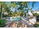 Inviting backyard pool area with outdoor seating, a spa, lush landscaping, and a fire pit at 1585 Chestnut Ave, Winter Park, FL 32789