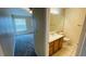 Hallway view to the bathroom with tile floors, wood vanity, and a bedroom beyond at 1932 Lake Atriums Cir # 74, Orlando, FL 32839