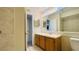 Well-lit bathroom featuring a large mirror, wood vanity, and tiled shower at 1932 Lake Atriums Cir # 74, Orlando, FL 32839