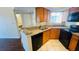 Well-lit kitchen featuring granite countertops, wooden cabinets, and appliances, adjacent to the bathroom at 1932 Lake Atriums Cir # 74, Orlando, FL 32839