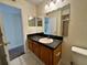 Cozy bathroom featuring a single sink vanity, practical fixtures, and a framed mirror at 1940 Lake Atriums Cir # 108, Orlando, FL 32839