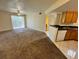 Open-concept, carpeted living area featuring a ceiling fan with a view into the kitchen at 1940 Lake Atriums Cir # 108, Orlando, FL 32839