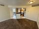 Carpeted living area featuring a ceiling fan with views into the kitchen and out to the balcony at 1940 Lake Atriums Cir # 108, Orlando, FL 32839