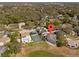 Aerial view of home shows backyard, tennis court, solar panels, and lush neighborhood with mature trees at 1946 Thoroughbred Dr, Gotha, FL 34734