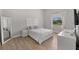 Bright, minimalist bedroom with a sleek white bedframe, wood floors and a window at 1946 Thoroughbred Dr, Gotha, FL 34734