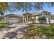 Charming single-story home with manicured lawn, arched entryway, and a spacious driveway leading to a two-car garage at 1946 Thoroughbred Dr, Gotha, FL 34734