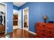 Bright bedroom with wood floors, blue walls, and a view into the kitchen and bathroom at 1990 Appalachee Cir, Tavares, FL 32778