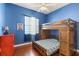 Cozy bedroom with a wooden bunk bed, hardwood floors, and natural light at 1990 Appalachee Cir, Tavares, FL 32778