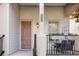 Welcoming front porch with a pink door, decorative flowers and a cozy seating area with a garden view at 1990 Appalachee Cir, Tavares, FL 32778