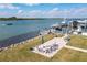 Scenic waterfront featuring a covered boat dock, a patio with chairs, and lush landscaping at 2100 N Peninsula Ave # 1020, New Smyrna Beach, FL 32169