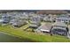 Aerial view of a home with a screened lanai and manicured lawn, nestled in a picturesque neighborhood near a lake at 2687 Chantilly Ave, Kissimmee, FL 34741