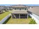 View of the home's screened-in lanai and the expansive grassy backyard at 2687 Chantilly Ave, Kissimmee, FL 34741