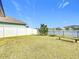 Inviting backyard with green grass, iron fencing, a tree, and a serene water view at 2687 Chantilly Ave, Kissimmee, FL 34741