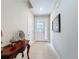 Bright foyer featuring a decorative table, neutral tile flooring, and a front door with sidelights at 2687 Chantilly Ave, Kissimmee, FL 34741