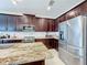 Kitchen featuring stainless steel refrigerator and appliances, with granite countertops and dark wood cabinets at 2687 Chantilly Ave, Kissimmee, FL 34741